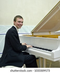 Happy Young Man Behind White Grand Piano