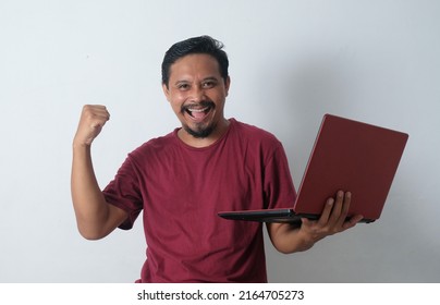 Happy Young Man Carrying Laptop In The Hand