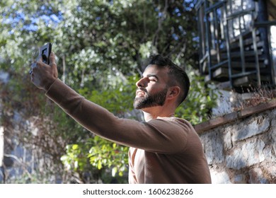 Happy Young Man Doing A Facetime With Friends Using A Smartphone