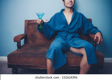 Happy Young Man In Dressing Gown Drinking Martini