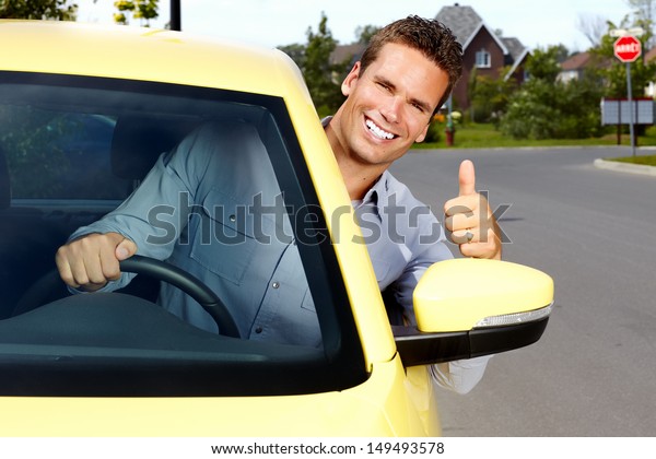 Happy young man driver in
a new car.