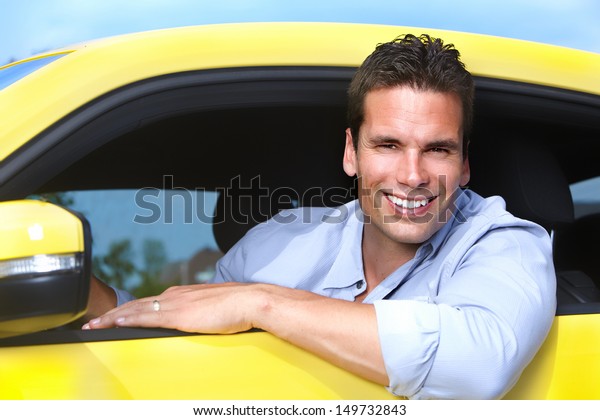 Happy young man driver in\
a new car.