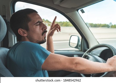 Happy young man driving a car dancing and singing. Fun trip, transportation and vehicle concept. - Shutterstock ID 1848542962
