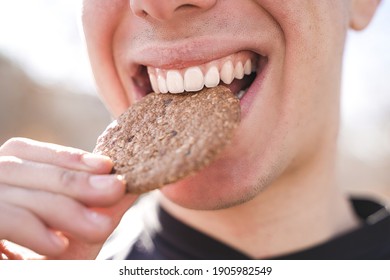 Happy young man eating cookie while smiles