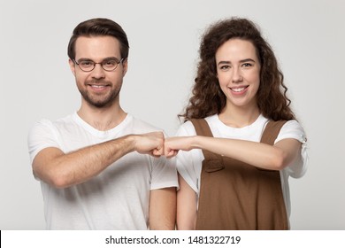 Happy Young Man In Eyewear Bumping Fists With Millennial Smiling Girl, Isolated On Grey White Studio Background. Family Couple Or Friends Come To Mutual Decision, Friendship, Relationship Concept.