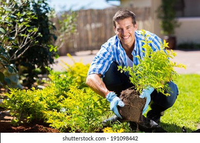 Happy Young Man Gardening In Backyard