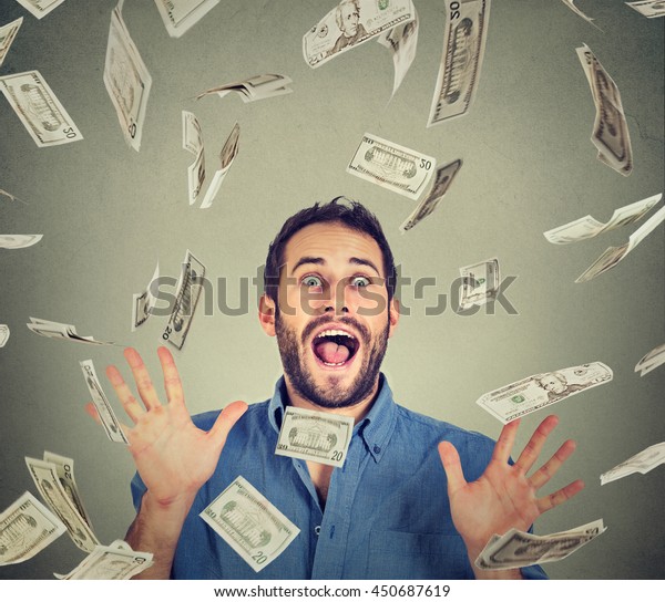 幸せな若い男が大喜びで叫び狂っている グレイの背景にドル紙幣が落ち込むお金の雨の中で ポートレートの歓喜に満ちた男性が成功を祝います 金融の自由のコンセプト の写真素材 今すぐ編集
