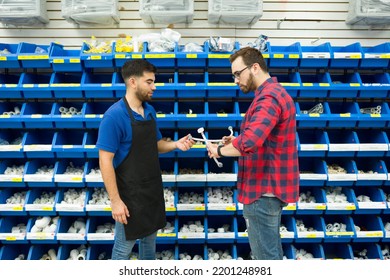 Happy Young Man And Hardware Store Employee Choosing New Piping For A Male Customer Buying Pipes 