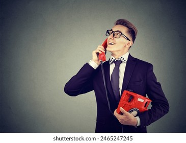 Happy young man having a romanic conversation over the red telephone  - Powered by Shutterstock