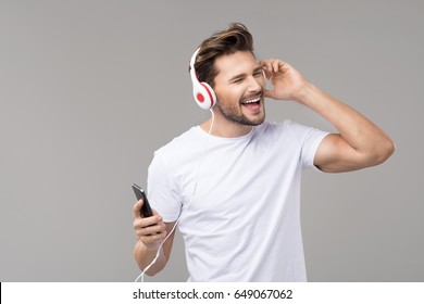 Happy Young Man With Headphones. Listening Music
