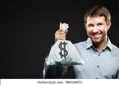 Happy Young Man Holding Money Bag And Looking At Camera