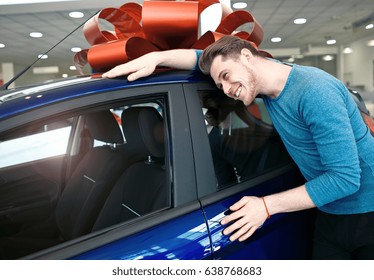 Happy Young Man Is Hugging His First Brand New Car.