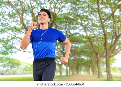 Happy Young Man Jogging In The City Park