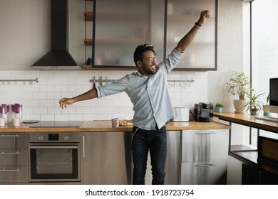 Happy Young Man Jump Dance Express Positive Emotions In Motion, After Moving To New Studio Flat. Excited African Guy Celebrate Successful, Purchase Of Large Modern Apartment