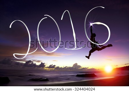 happy young man jumping  and drawing 2016 in the air