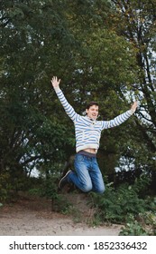 Happy young man jumping while enjoying the outdoors. Expression of emotions.