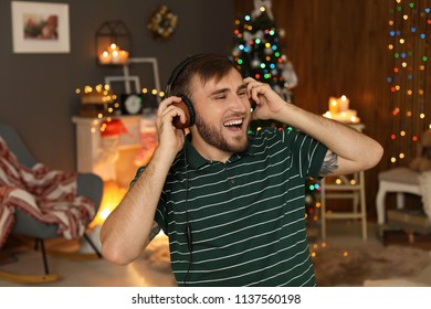 Happy Young Man Listening To Christmas Music At Home