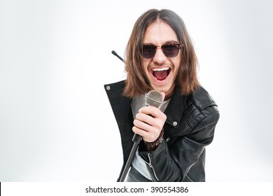 Happy young man with long hair in sunglasses using microphone for singing over white background - Powered by Shutterstock