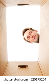 Happy Young Man Looking Inside Box