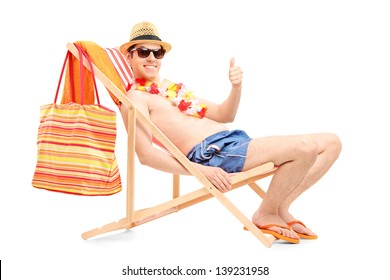 Happy Young Man On A Beach Chair Giving Thumb Up Isolated On White Background