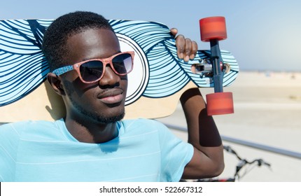 Happy young man outdoors holding his skateboard - Powered by Shutterstock