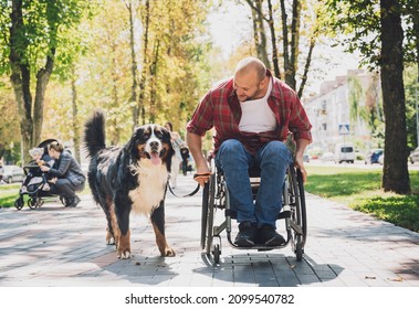 Happy Young Man With A Physical Disability Who Uses Wheelchair With His Dog.