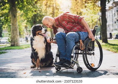 Happy young man with a physical disability who uses wheelchair with his dog. - Powered by Shutterstock