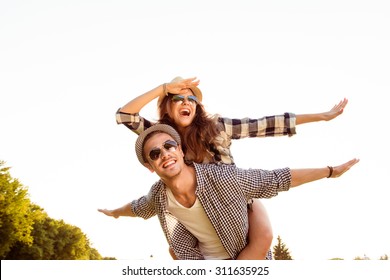 Happy young man piggybacking his girlfriend.  - Powered by Shutterstock