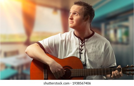 Happy Young Man Playing Guitar Outside The Home