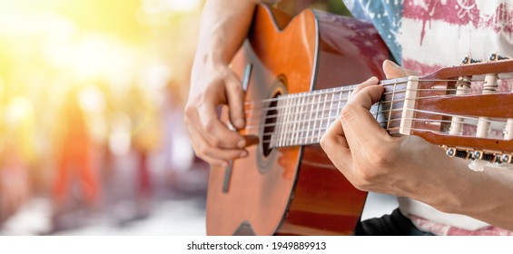 Happy Young Man Playing Guitar Outside The Home