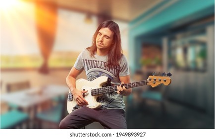 Happy Young Man Playing Guitar Outside The Home