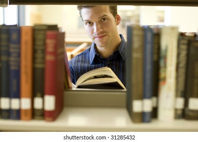 Happy Young Man Researching Info At A Library