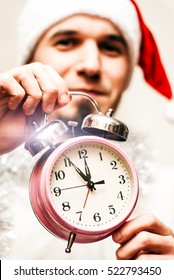 Happy Young Man in Santa Hat with the Clock. new year concept