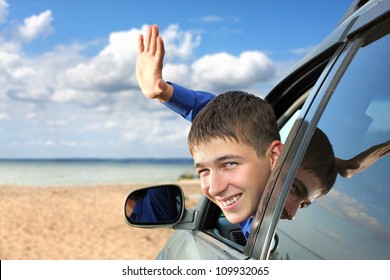 Happy Young Man Sitting In The Car And Wave Goodbye