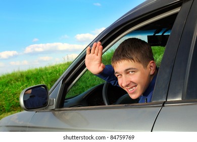 Happy Young Man Sitting In The Car And Wave Goodbye