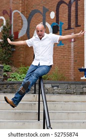 A Happy Young Man Sliding Down A Railing On A Stairway.