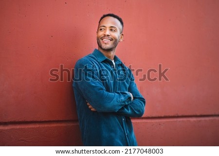 Similar – Image, Stock Photo Hispanic guy leaning on hand sitting against colorful illumination with opened mouth