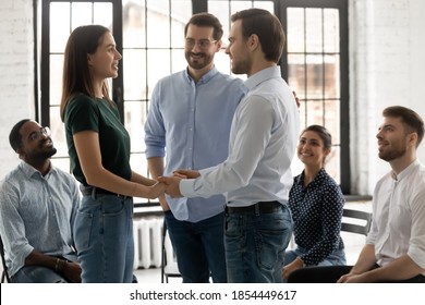 Happy Young Man Succeeded In Getting Rid Of Addiction Depression Holding Hands Of Female With Same Problem Giving Support Hope On Recovery Under Control Of Professional Psychologist At Group Therapy.