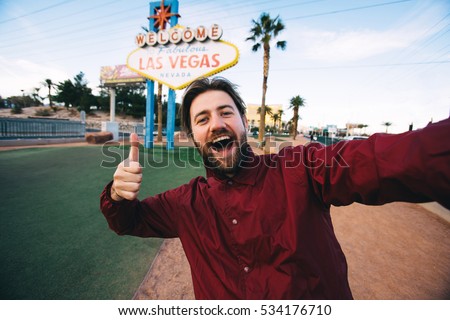 Happy young man taking selfie near Las Vegas Welcome sign. Handsome having fun near Las Vegas billboard on the background, Nevada, USA