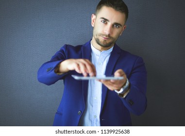 Happy young man using digital tablet isolated on grey background