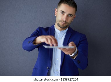Happy young man using digital tablet isolated on grey background