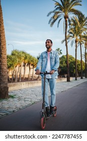 Happy young man using his electric scooter to go to work. He is eco friendly. - Shutterstock ID 2247787455