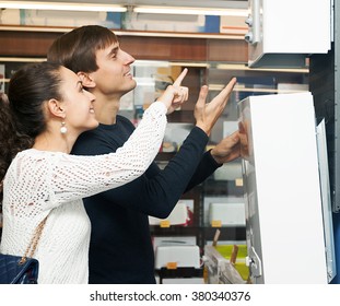 Happy Young Man And Woman Buying New Heating Water Boiler 