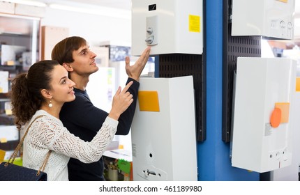 Happy Young Man And Woman Choosing New Heating Water Boiler