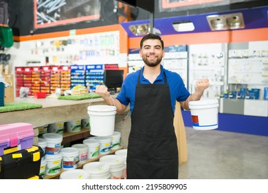 Happy Young Man Worker Holding A Bucket Of Paint And Waterproofer To Show A Customer At The Hardware Store