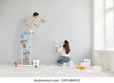 Happy young married couple enjoying wall painting, enjoy home renovation fun, decorate, repair after moving into new house, excited homeowners, renters, man and woman feeling joy, working together - Powered by Shutterstock