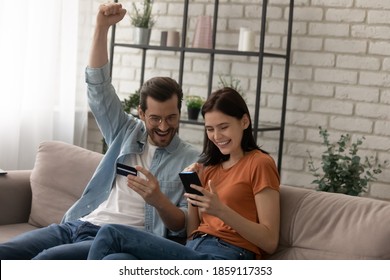 Happy young married family couple involved in online shopping, celebrating getting gift or winning prize in giveaway, paying for goods or services with credit bank card in smartphone application. - Powered by Shutterstock