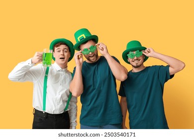 Happy young men in leprechaun's hats with beer on yellow background. St. Patrick's Day celebration - Powered by Shutterstock