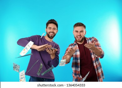 Happy Young Men Throwing Money On Color Background