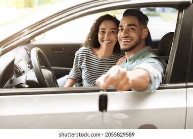 Happy Young Middle-eastern Couple Showing Key From New Car, Smiling Arab Man And Woman Sitting Inside New Luxury Auto, Copy Space. Car Renting, Leasing, Buying, Dealership, Auto Retail Concept